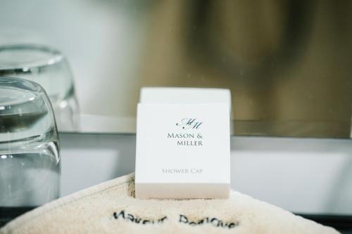 a white card sitting on a table next to a glass at The Old Fourpenny Hotel in Warwick
