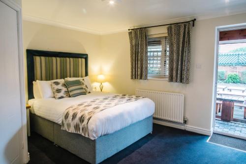 a bedroom with a bed and a window at The Old Fourpenny Hotel in Warwick
