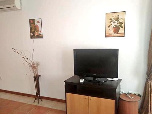 a flat screen tv sitting on top of a wooden cabinet at Apartment on the sea at St Nikolas Complex-Ekaterina in Chernomorets