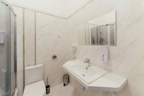 een witte badkamer met een wastafel en een toilet bij Діамант ЛПК ГТРС in Lviv