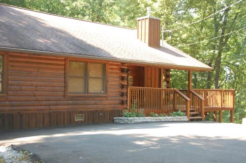 a log cabin with a porch and a deck at His Promises Cabin in Pigeon Forge