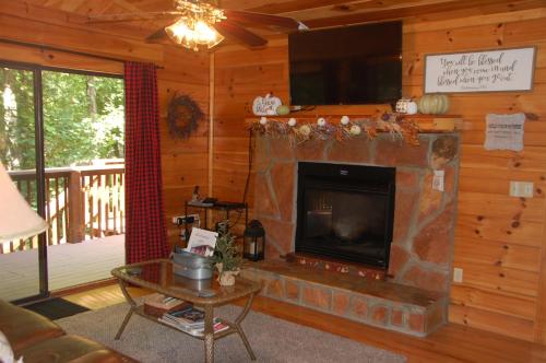 a living room with a fireplace and a tv at His Promises Cabin in Pigeon Forge