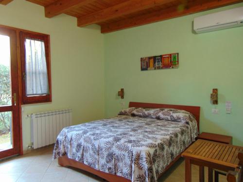 Un dormitorio con una cama y una mesa. en La Contea en SantʼAnna Arresi