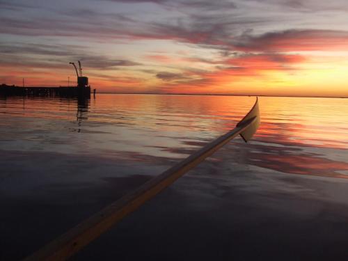 a boat in the water with a sunset at Gran Hotel Fray Bentos in Fray Bentos