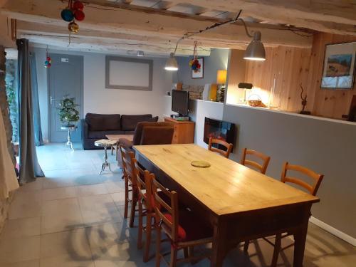 a kitchen and living room with a wooden table and chairs at Le val de coussane in Coubisou