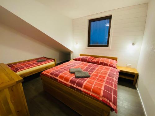 a bedroom with two beds and a window at Apartmány Poludnica Chopok Juh in Tale