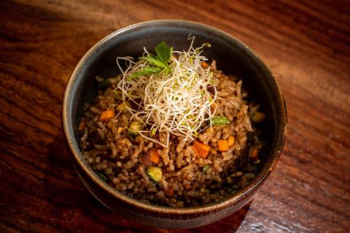a bowl of food sitting on a wooden table at Dreams Jade Resort & Spa - All Inclusive in Puerto Morelos