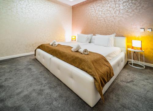 a bedroom with a large white bed with a brown blanket at Tsarevets Boutique Hotel & SPA in Veliko Tŭrnovo