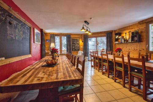 een eetkamer met een lange houten tafel en stoelen bij Gîte Ancolie Bleue in Abriès