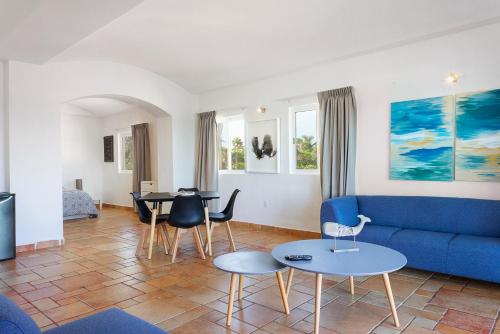 a living room with a blue couch and tables at Caleta Tankah in Tulum