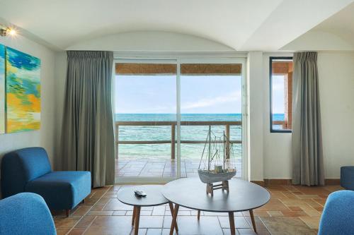 a living room with a view of the ocean at Caleta Tankah in Tulum