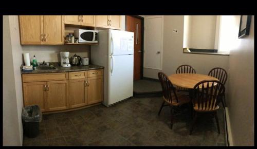a kitchen with a table and a white refrigerator at BUDGET LODGE in Saskatoon