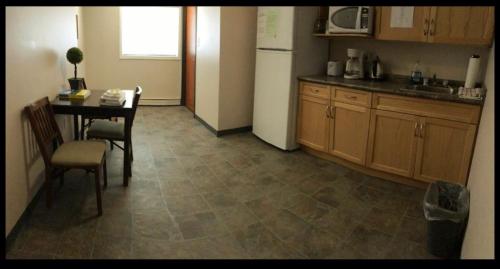 a kitchen with a table and a refrigerator at BUDGET LODGE in Saskatoon