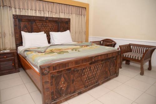 1 cama grande con marco de madera en una habitación en Stay Inn Guest House, en Karachi