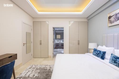 a bedroom with a large white bed and a desk at bnbmehomes - Private Beach in a Resort with DJ & Infinity Pool - 10201 in Dubai
