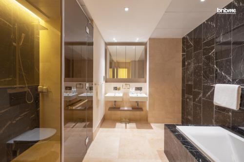 a bathroom with two sinks and a bath tub at bnbmehomes - Private Beach in a Resort with DJ & Infinity Pool - 10201 in Dubai