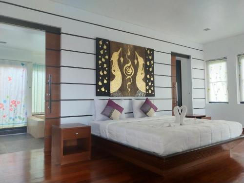 a bedroom with a large bed in a room at The Phura Villa Khaolak - SHA Extra Plus in Khao Lak