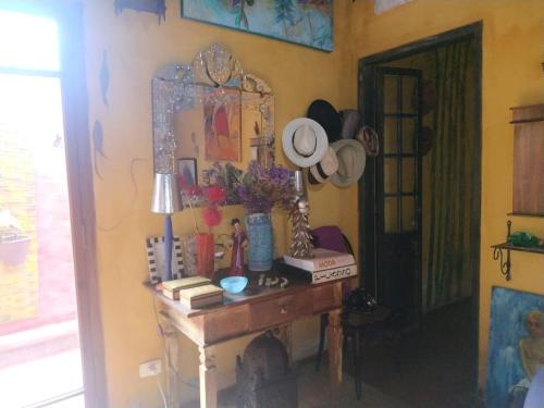 a room with a desk with a mirror and a table with books at Vila Santa Rosa Guest House in Ilhabela