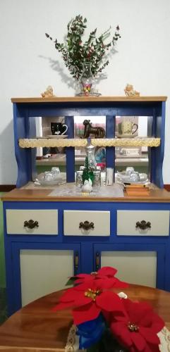 a blue dresser with a table and flowers on it at Casa Palagui Colonial in Valladolid