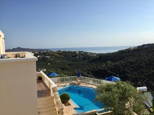a villa with a swimming pool and a view of the ocean at Ilios Village in Stalos