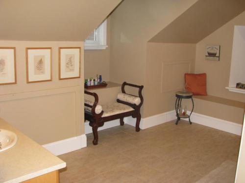 a bathroom with a chair and a sink at Clyde Hall Bed and Breakfast in Lanark