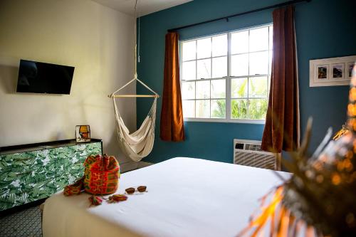 1 dormitorio con 1 cama, ventana y hamaca en Numero Uno Beach Apartments, en San Juan