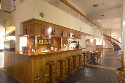 a bar in a restaurant with tables and chairs at Hotel Libertador in Tandil