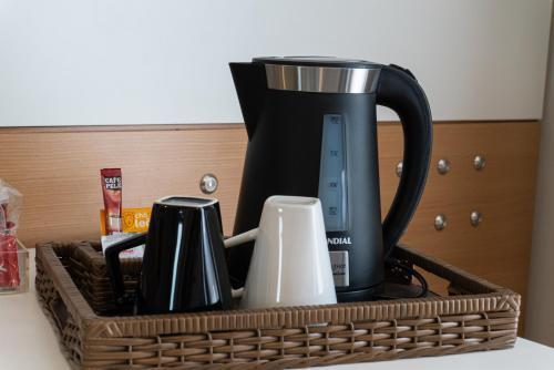 a black coffee maker in a basket on a counter at Quality Faria Lima in Sao Paulo