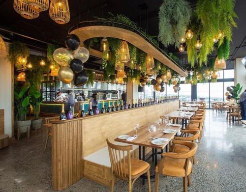 a restaurant with tables and chairs and a bar at Umhlanga Arch - Ocean Views, Queen size bed plus free wifi in Durban