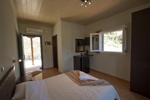 a bedroom with a white bed and white walls at Lefkas Petra in Agios Nikitas