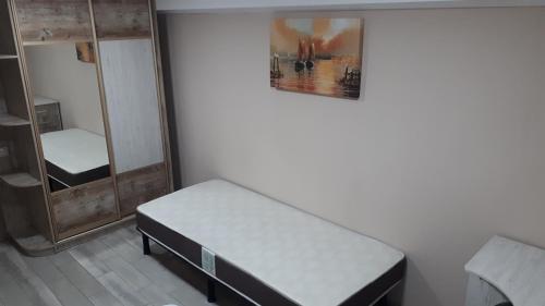 Habitación pequeña con cama y espejo. en Отдельные номера в гостевом доме guest house, en Kropyvnytskyi