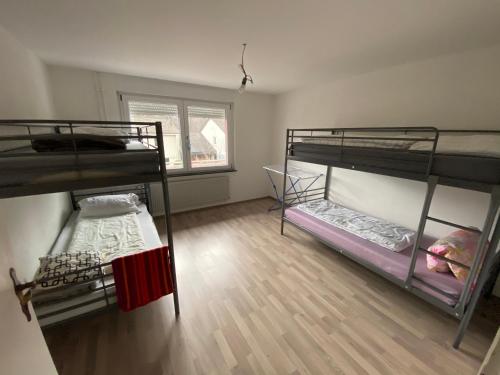 a room with three bunk beds and a wooden floor at Tokis Feriendomizil 2.0 in Bad Säckingen