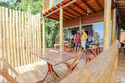 twee personen op een patio met een tafel en stoelen bij Campos Elísios Boipeba in Ilha de Boipeba