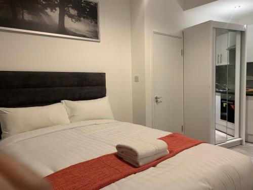 una camera da letto con un grande letto bianco con testiera nera di Frances St House a Londra