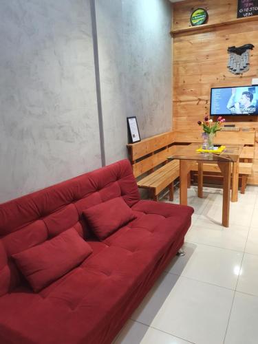 a red couch in a living room with a table at Aconchego do Vale in Blumenau