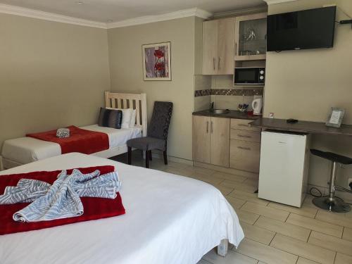 a hotel room with two beds and a kitchen at Chic Breeze in Bloemfontein
