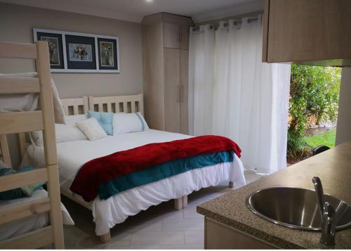 a bedroom with a bed and a sink and a kitchen at Chic Breeze in Bloemfontein