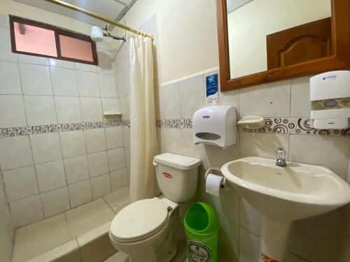 a small bathroom with a toilet and a sink at Hostal Vista al Mar in Puerto Ayora