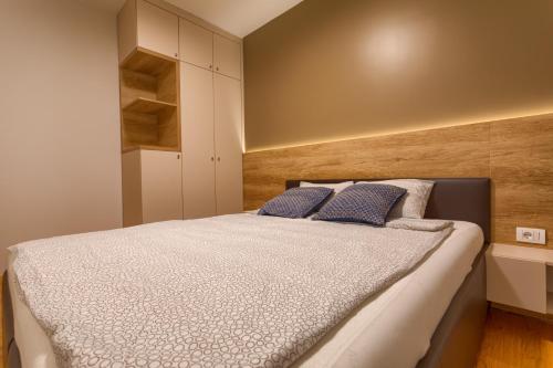 a bedroom with a large bed with blue pillows at Dejana Apartment in Zlatibor