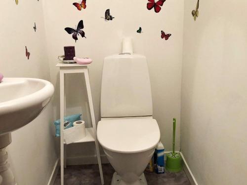 a bathroom with a toilet and butterflies on the wall at Tranquil Retreat in Halsingland-By Traum in Kårböle