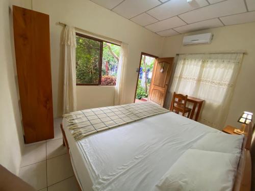 a bedroom with a bed and a window at Hostal Vista al Mar in Puerto Ayora