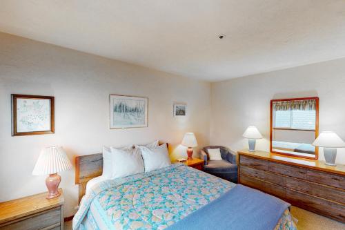 a bedroom with a bed and a chair and a mirror at Nye Beach Lighthouse Vista in Newport