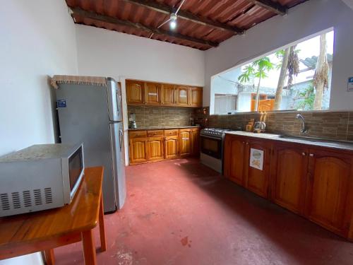 a kitchen with wooden cabinets and a stainless steel refrigerator at Hostal Vista al Mar in Puerto Ayora