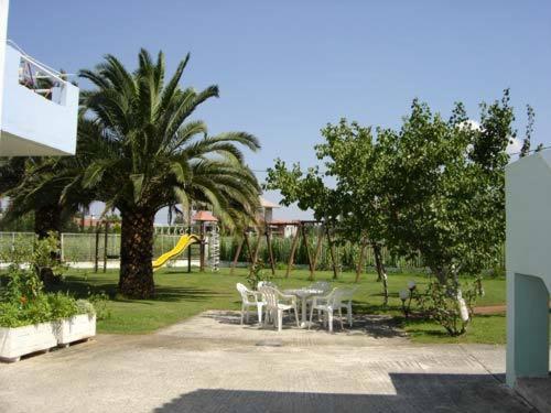 a park with a table and chairs and a slide at 7Syn7 in Oreoí
