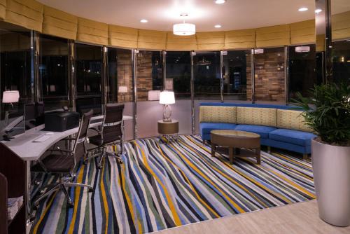 an office with a couch and a desk and chairs at Holiday Inn Express & Suites Pasadena - Los Angeles by IHG in Pasadena