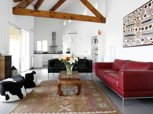 ein Wohnzimmer mit einem roten Sofa und einem Tisch in der Unterkunft Exotic Holiday Home in Ceps with Private Pool in Cazedarnes
