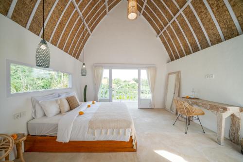 1 dormitorio con cama y ventana grande en Kelana Uluwatu en Uluwatu