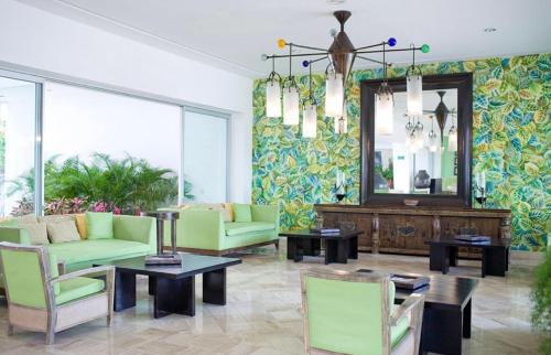 uma sala de estar com mobiliário verde e um espelho em Vidanta Sea Garden Nuevo Vallarta em Nuevo Vallarta