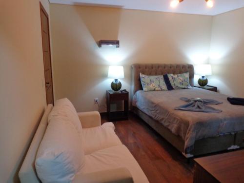 a bedroom with a bed and a couch in it at Monte Verde Inn Suítes com Hidromassagem dupla in Monte Verde
