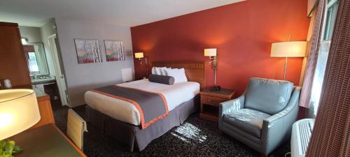 Habitación de hotel con cama y silla en Dow Villa Motel en Lone Pine